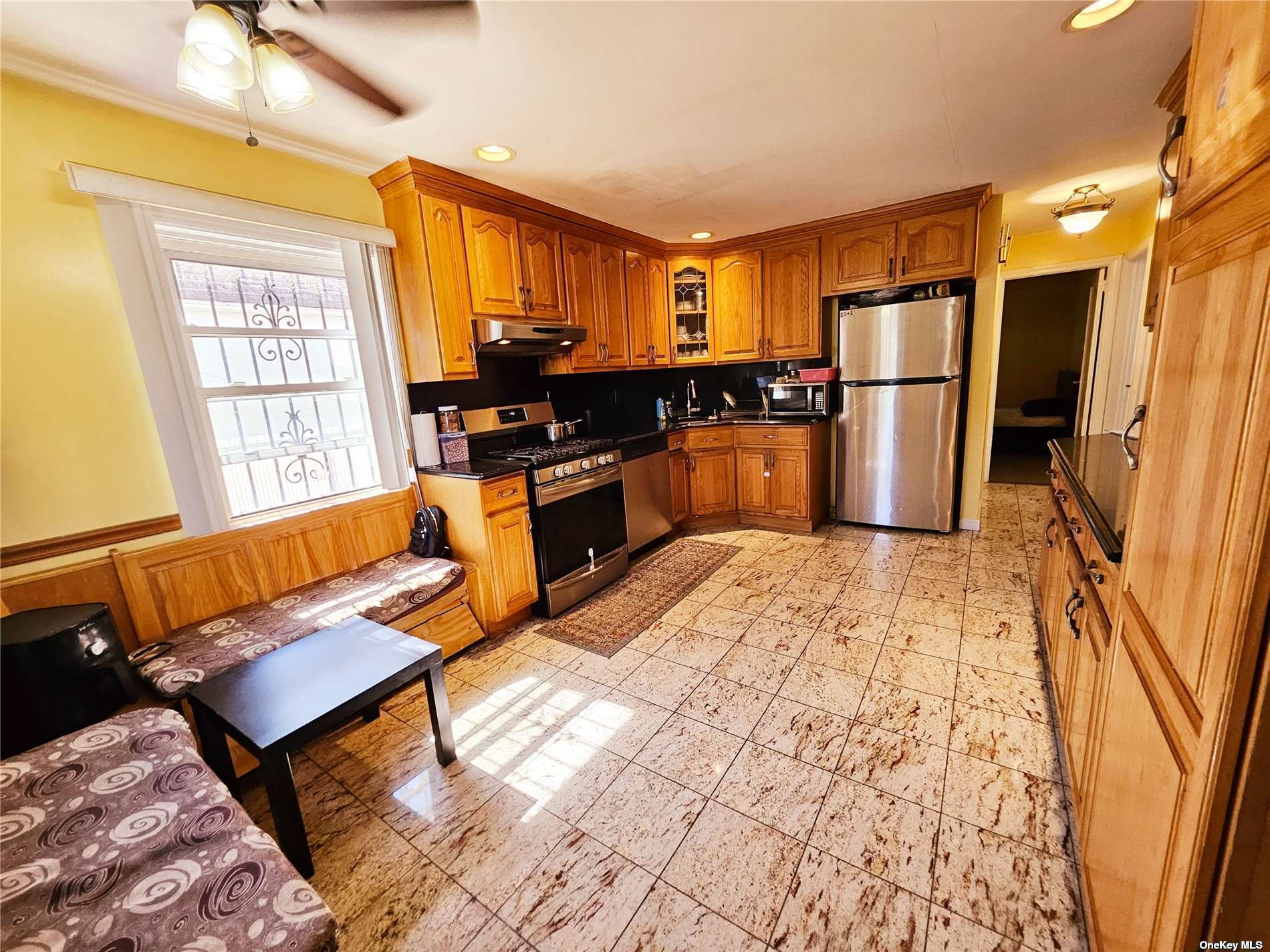 a large kitchen with stainless steel appliances kitchen island granite countertop a refrigerator and a stove top oven