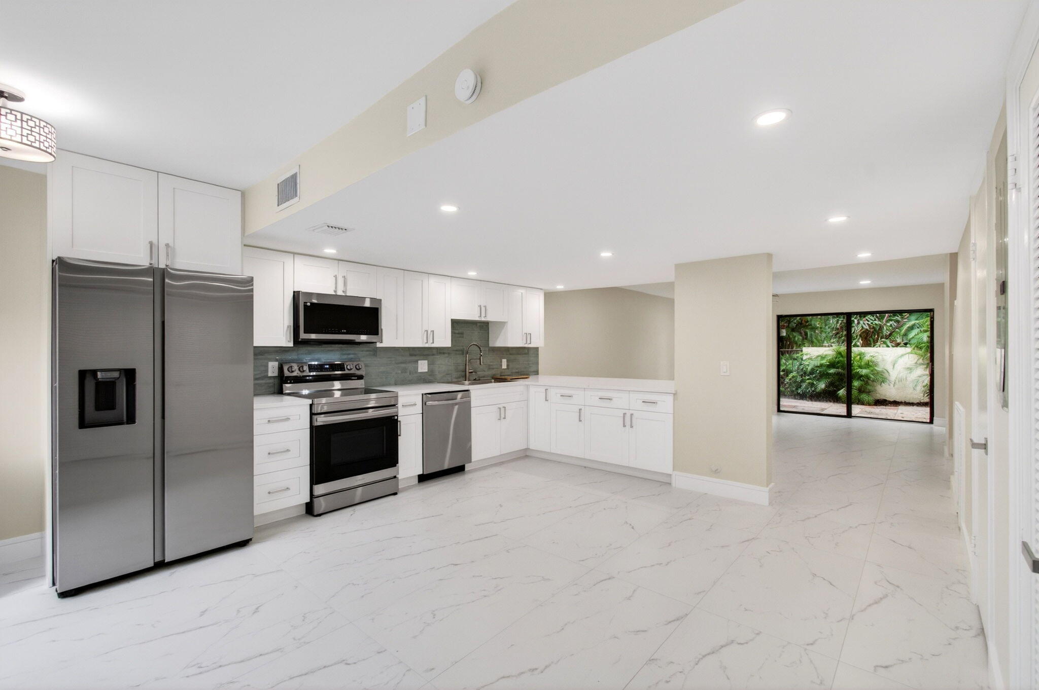1330 Northwest 13th Street, Unit 12 Boca Raton, FL 33486 - Photo 1 of 52 a kitchen with stainless steel appliances a refrigerator sink and stove