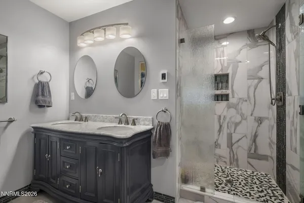 a bathroom with a double vanity sink mirror and shower