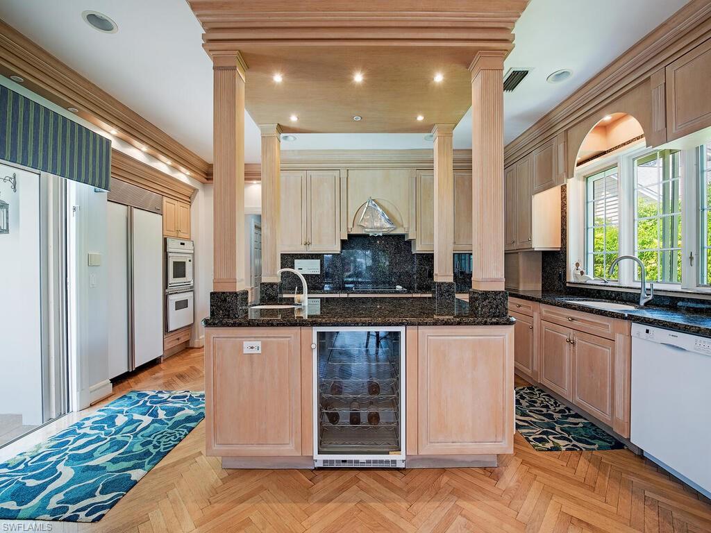 3495 Gin Lane Naples, FL 34102 - Photo 13 of 18 a large kitchen with kitchen island granite countertop a large window and stainless steel appliances