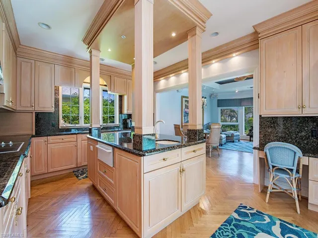 a kitchen with granite countertop a stove a sink and a refrigerator