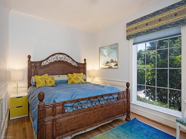 a bed sitting in a bedroom next to a window