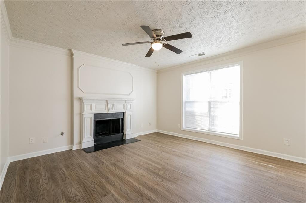 4011 Riverside Parkway Decatur, GA 30034 - Photo 5 of 27 an empty room with wooden floor a fireplace and windows