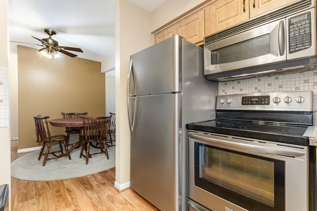 a kitchen with stainless steel appliances a stove a microwave and dining table