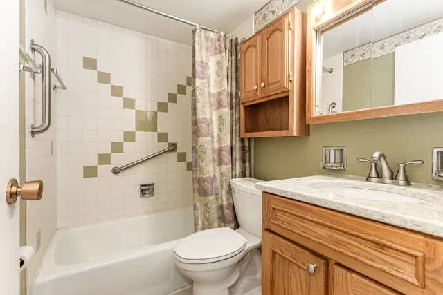 a bathroom with a granite countertop sink toilet and shower