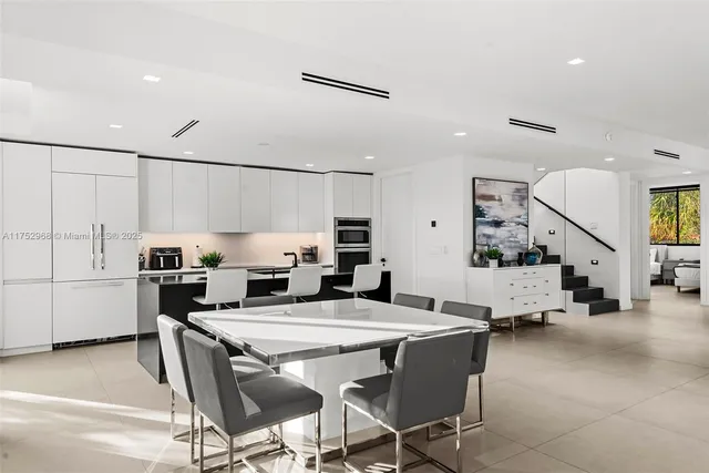a kitchen with a table chairs refrigerator and cabinets