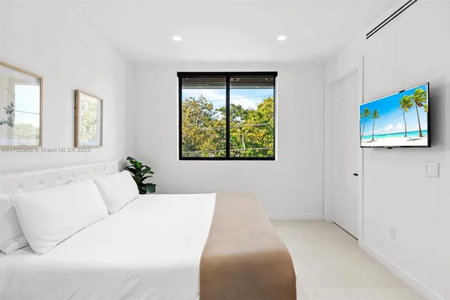 a bedroom with a bed and a large window