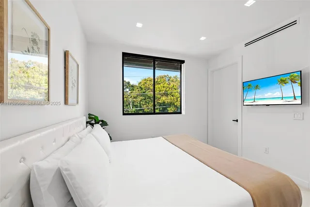 a bedroom with a bed and a painting on the wall