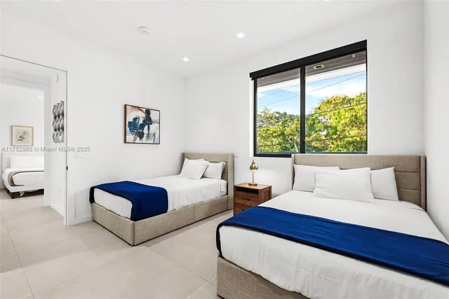 a bedroom with two beds and a window