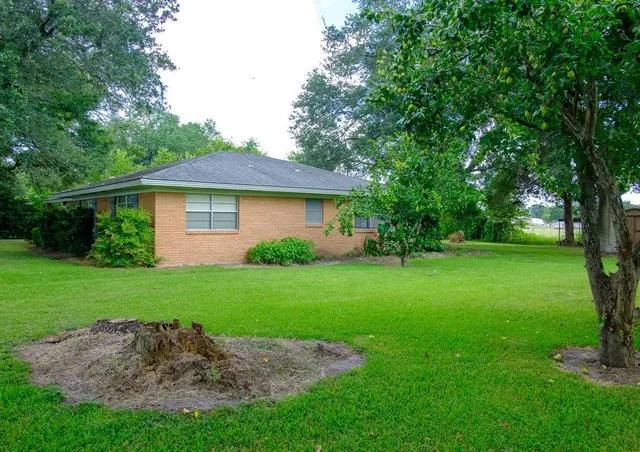 a front view of a house with a yard and trees