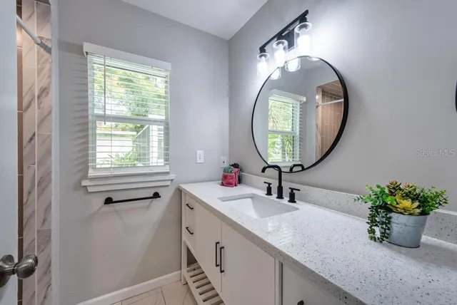 a bathroom with a sink a mirror and a window
