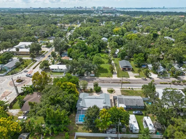 an aerial view of residential houses with outdoor space and trees