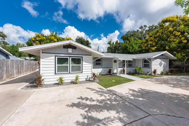 a front view of a house with a yard and outdoor seating