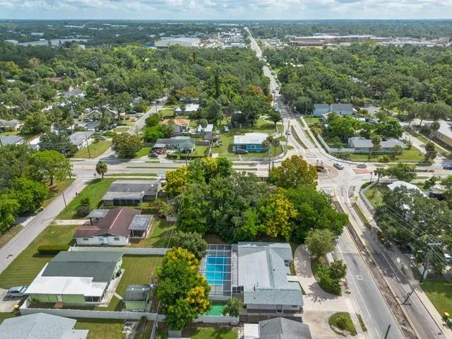 an aerial view of residential houses with outdoor space and trees