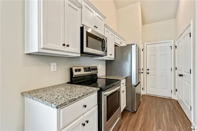 a kitchen with stainless steel appliances granite countertop a stove a refrigerator and a microwave