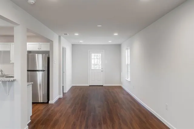 a view of empty room with wooden floor