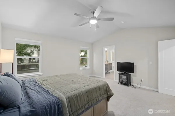 a spacious bedroom with a large bed and a flat tv screen on dresser