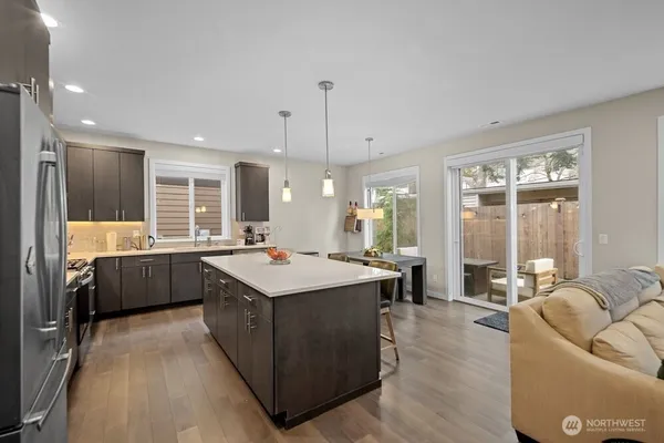 a kitchen with kitchen island a sink a counter top space stainless steel appliances and a window