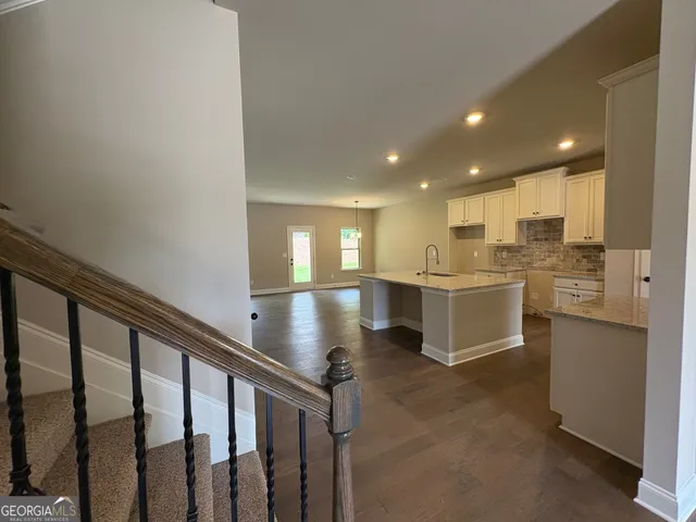 a open kitchen with white cabinets and white appliances