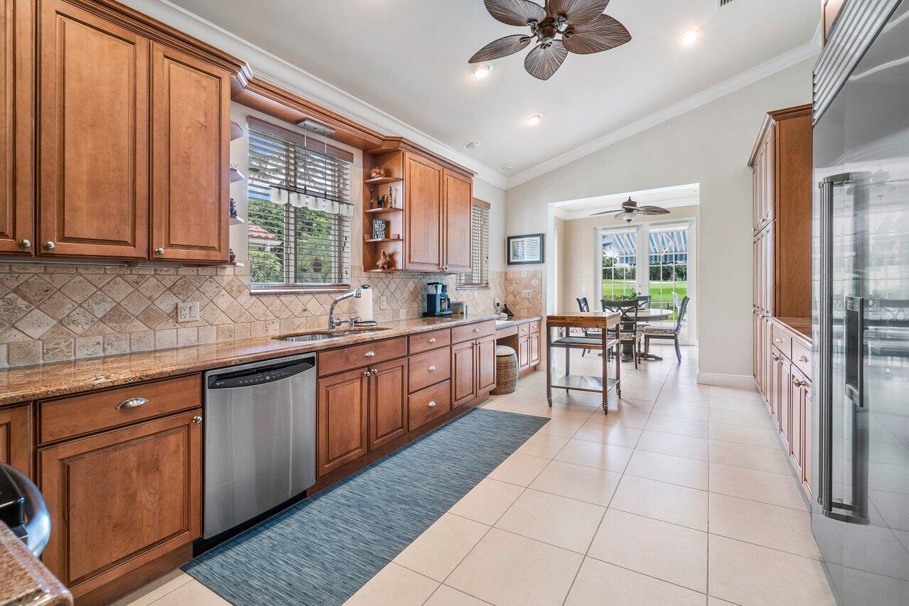 13548 Verde Drive Palm Beach Gardens, FL 33410 - Photo 15 of 43 a large kitchen with kitchen island granite countertop a large counter top space appliances and cabinets