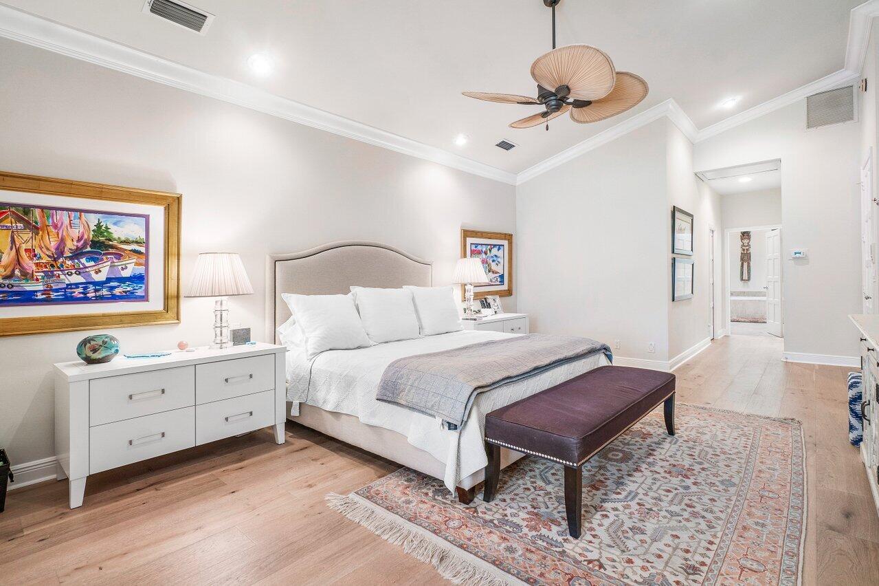 13548 Verde Drive Palm Beach Gardens, FL 33410 - Photo 18 of 43 a spacious bedroom with a bed and a chandelier