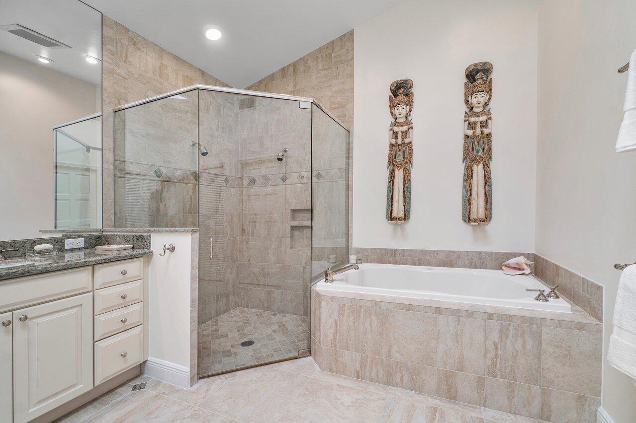 13548 Verde Drive Palm Beach Gardens, FL 33410 - Photo 20 of 43 a spacious bathroom with a granite countertop sink a mirror a shower and a bathtub