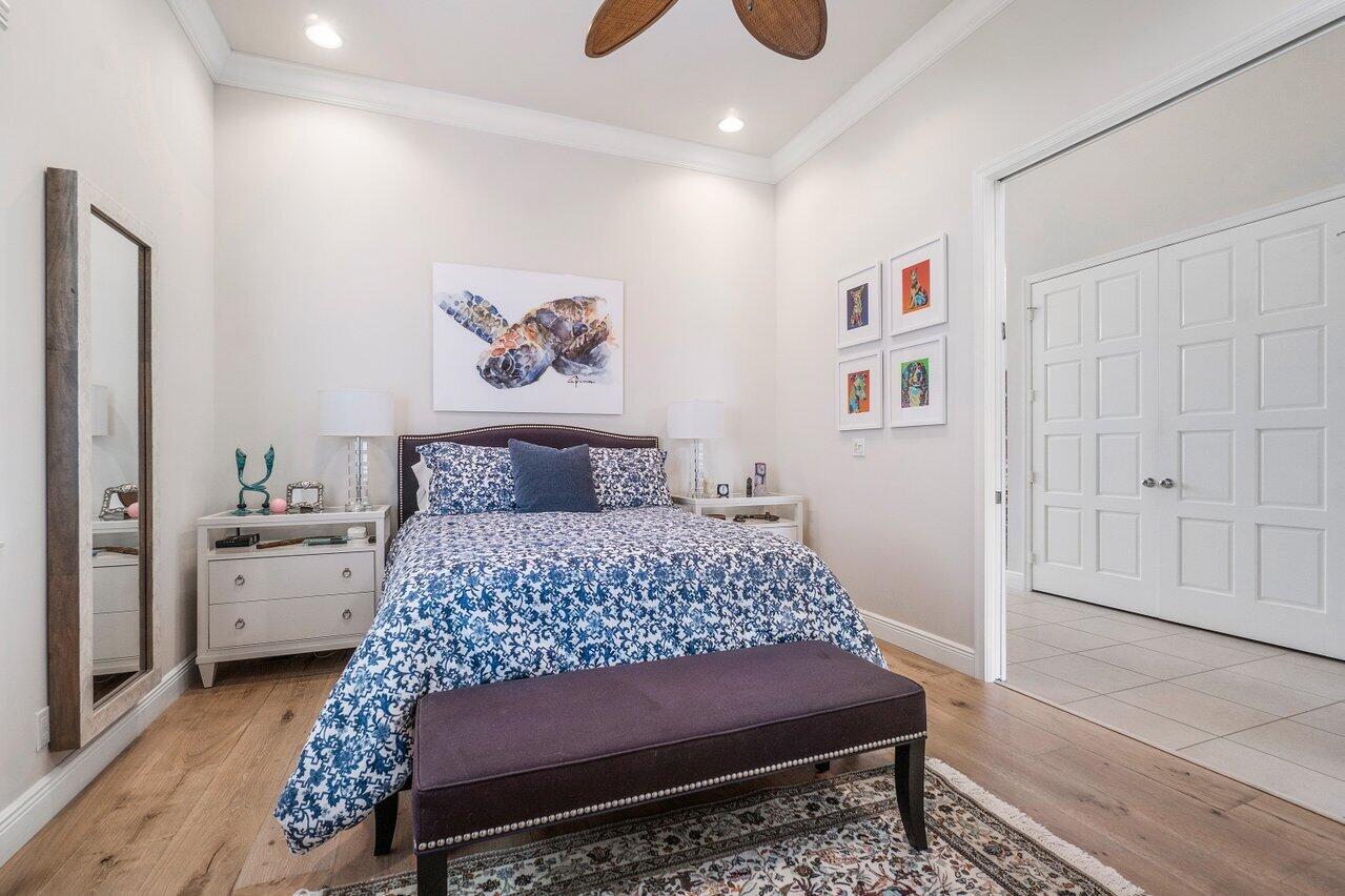 13548 Verde Drive Palm Beach Gardens, FL 33410 - Photo 22 of 43 a bedroom with a large bed and a chandelier