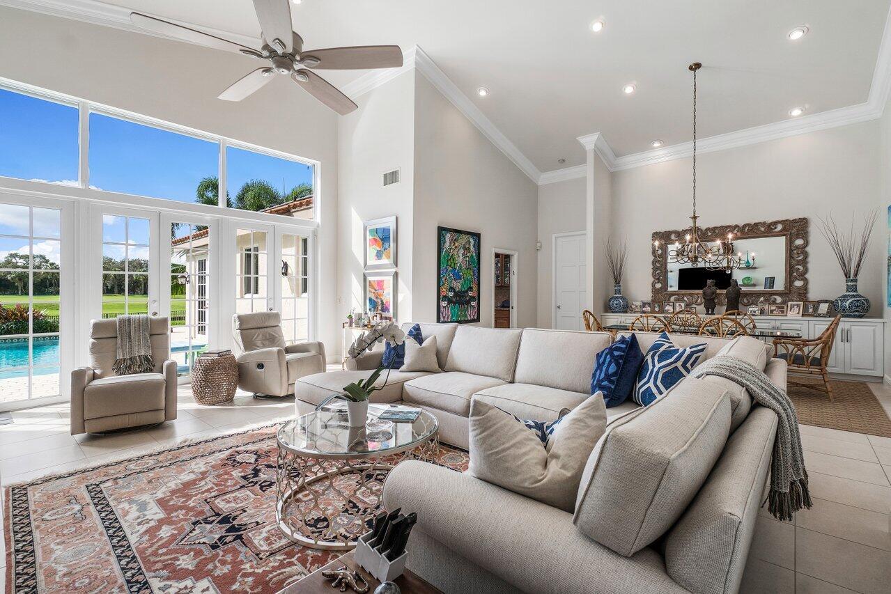 13548 Verde Drive Palm Beach Gardens, FL 33410 - Photo 9 of 43 a living room with furniture a ceiling fan and a flat screen tv