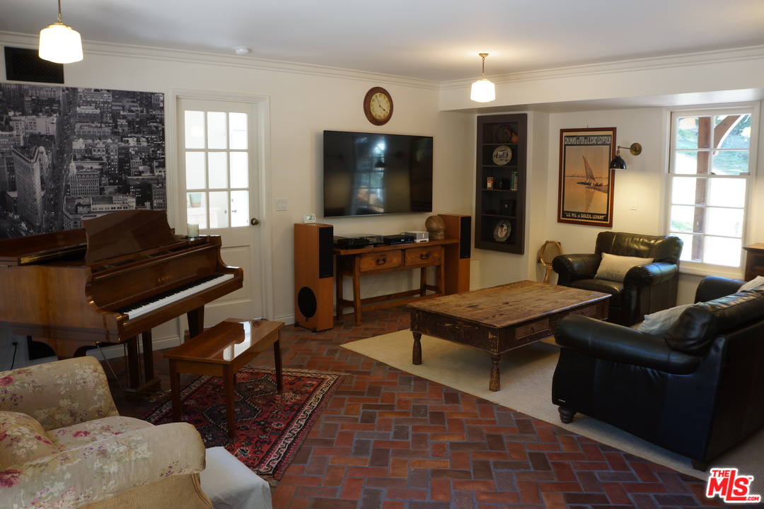 919 Rivas Canyon Road Pacific Palisades, CA 90272 - Photo 11 of 43 a living room with furniture and a flat screen tv