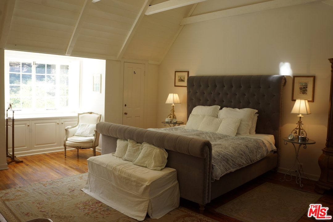 919 Rivas Canyon Road Pacific Palisades, CA 90272 - Photo 16 of 43 a spacious bedroom with a bed and chair