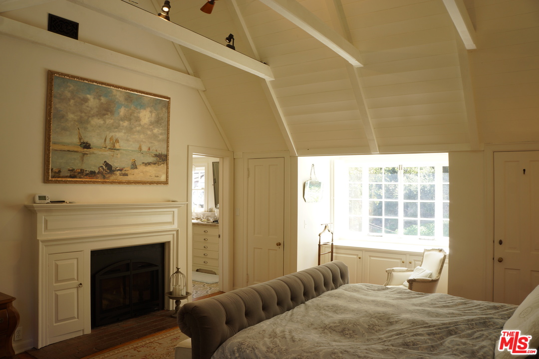 919 Rivas Canyon Road Pacific Palisades, CA 90272 - Photo 17 of 43 a bedroom with a bed and a fireplace