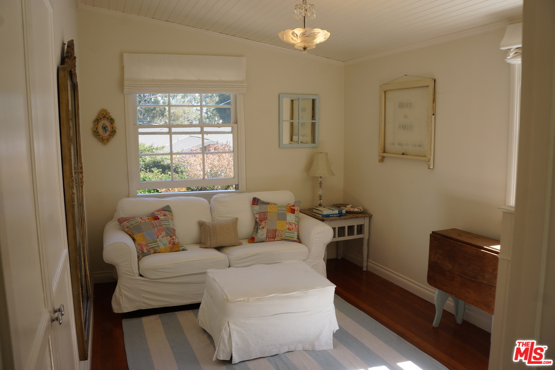 919 Rivas Canyon Road Pacific Palisades, CA 90272 - Photo 24 of 43 a living room with furniture a large window and a flat screen tv
