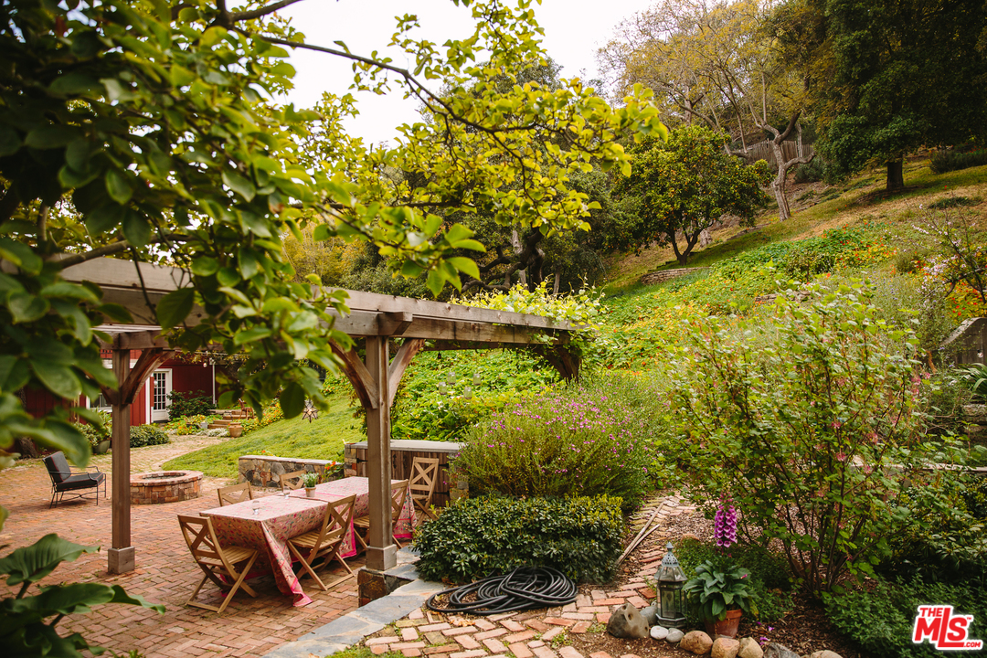 919 Rivas Canyon Road Pacific Palisades, CA 90272 - Photo 38 of 43 a backyard of a house with table and chairs