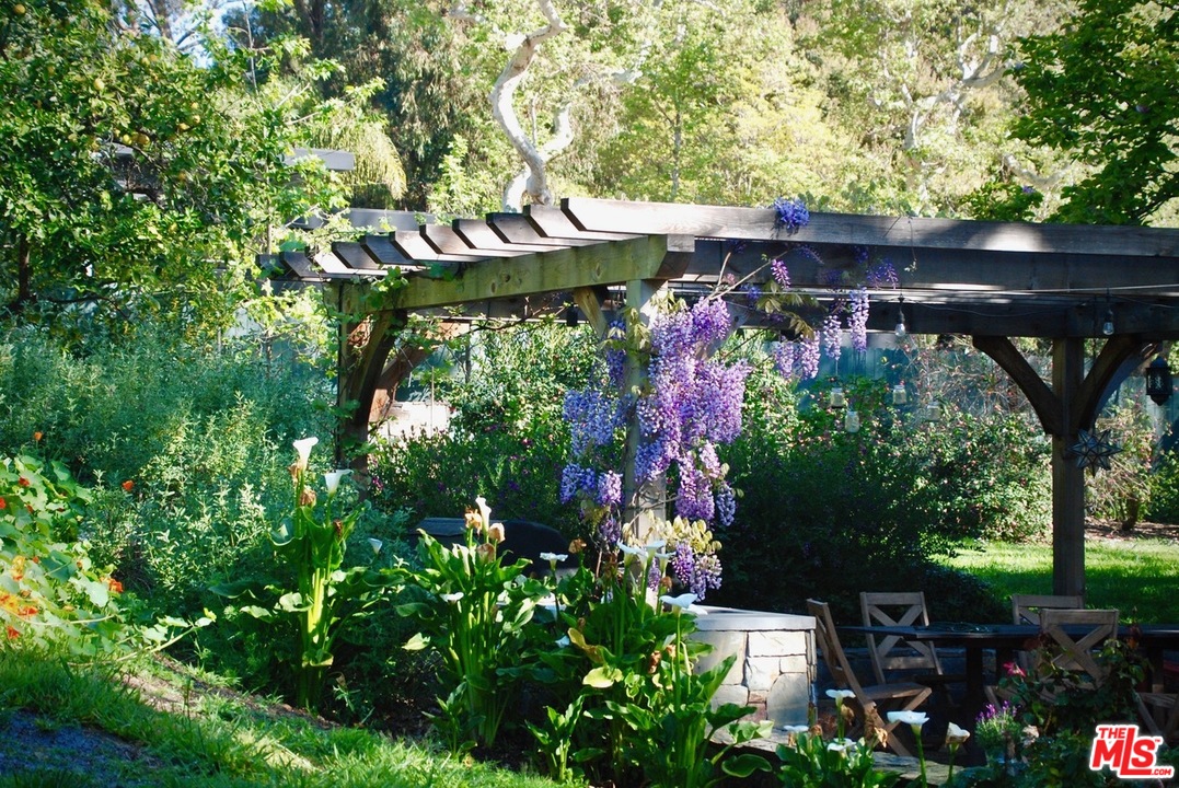 919 Rivas Canyon Road Pacific Palisades, CA 90272 - Photo 40 of 43 a backyard of a house with lots of green space and a fountain