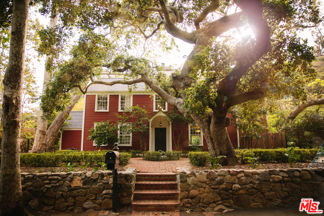 919 Rivas Canyon Road Pacific Palisades, CA 90272 - Photo 4 of 43 a front view of a house with a yard