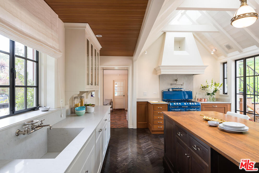919 Rivas Canyon Road Pacific Palisades, CA 90272 - Photo 9 of 43 a kitchen with stainless steel appliances granite countertop a sink a stove and a refrigerator