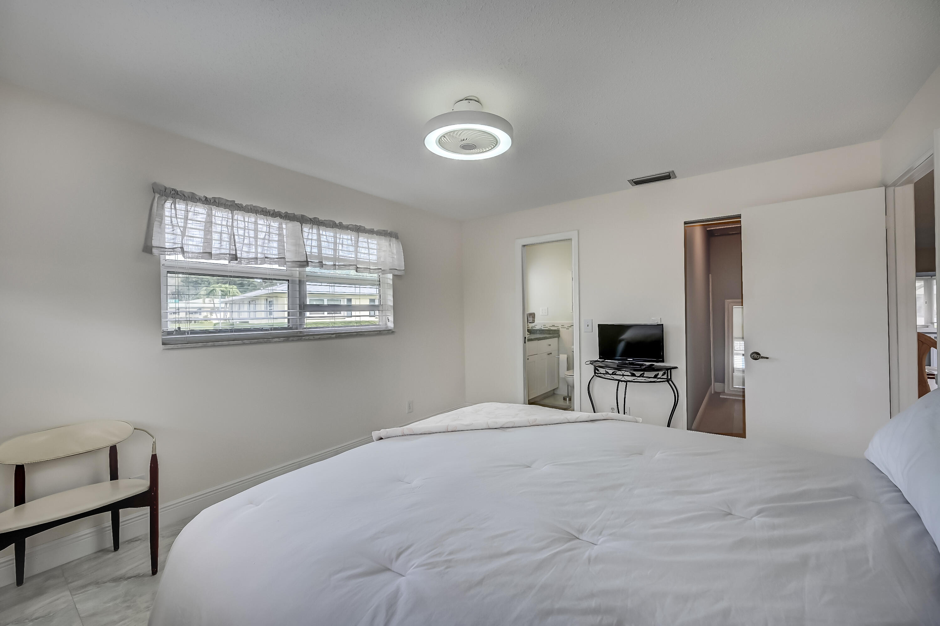 227 Cardinal Lane Delray Beach, FL 33445 - Photo 17 of 38 a bedroom with a bed and a chandelier