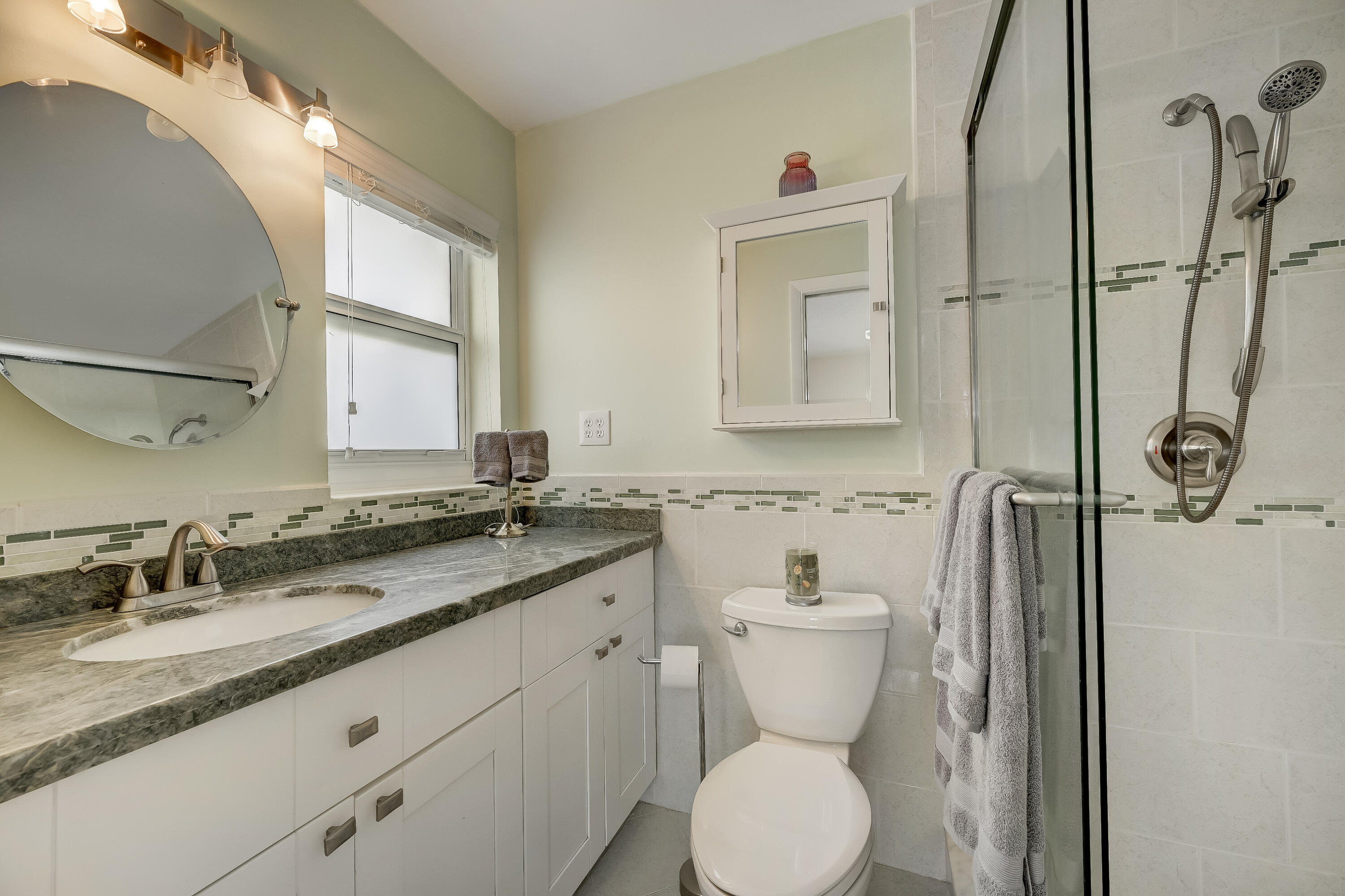 227 Cardinal Lane Delray Beach, FL 33445 - Photo 18 of 38 a bathroom with a granite countertop toilet sink and mirror