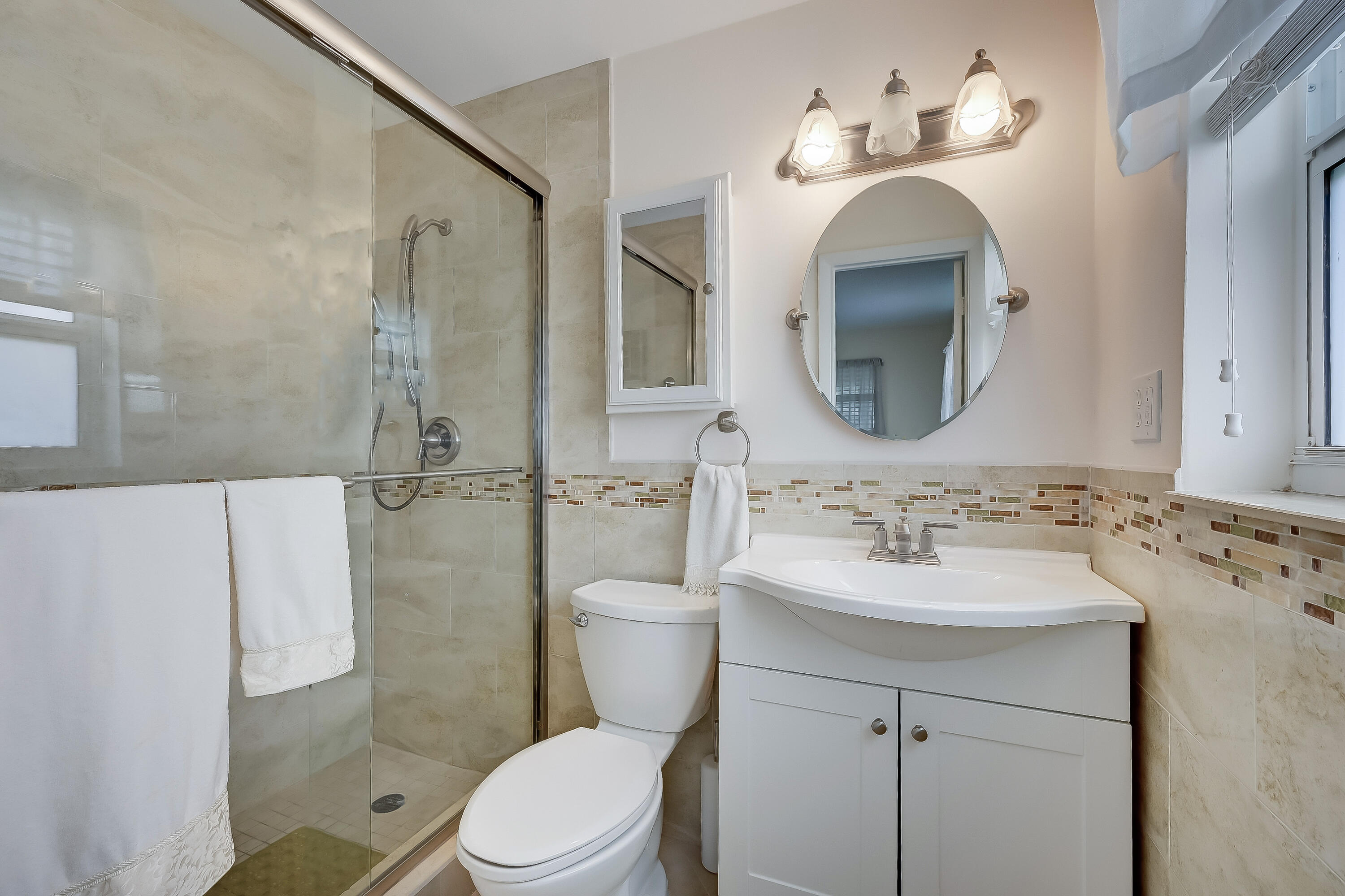 227 Cardinal Lane Delray Beach, FL 33445 - Photo 21 of 38 a bathroom with a sink vanity mirror and toilet