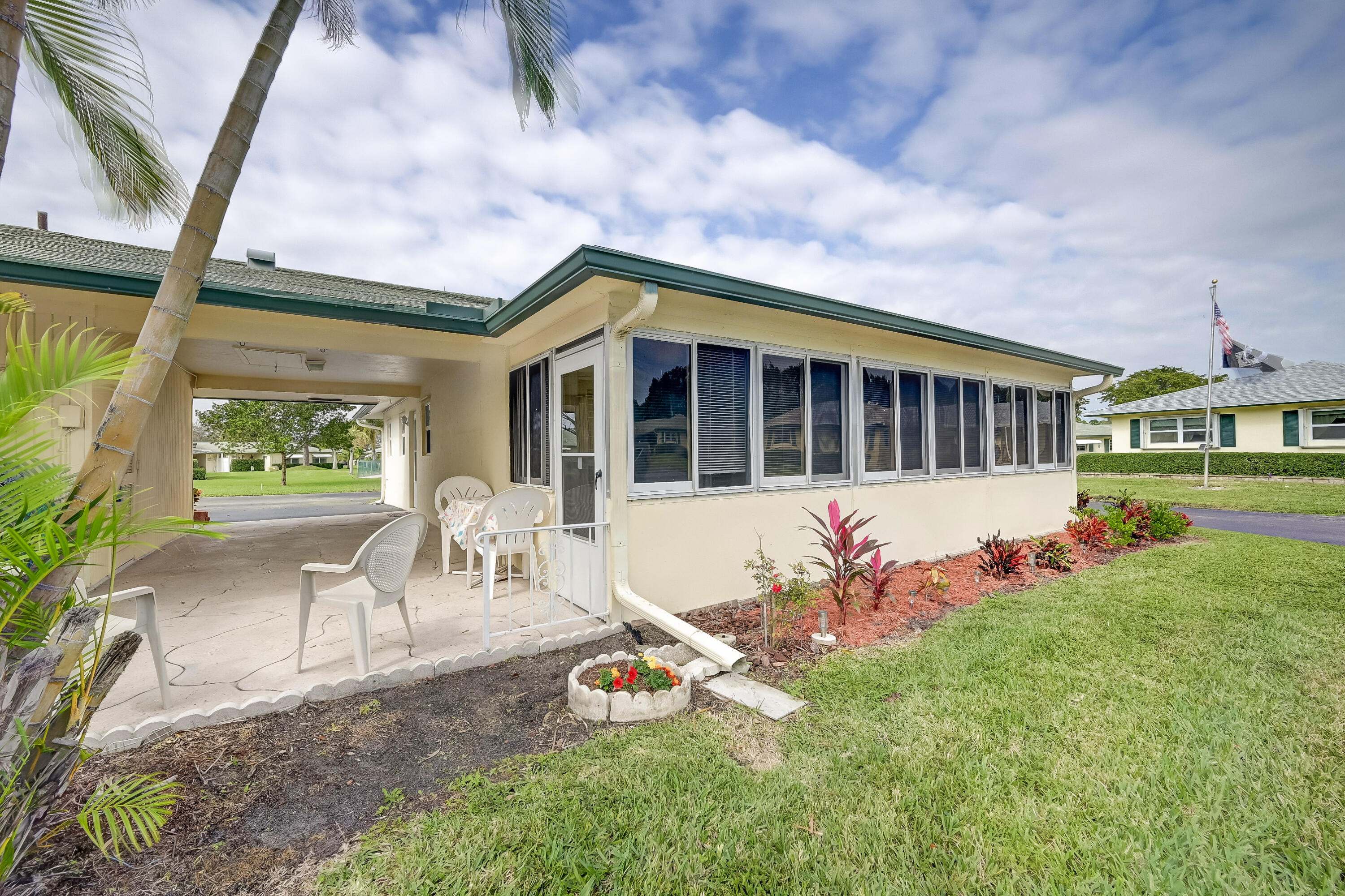 227 Cardinal Lane Delray Beach, FL 33445 - Photo 25 of 38 a front view of a house with a yard table and chairs
