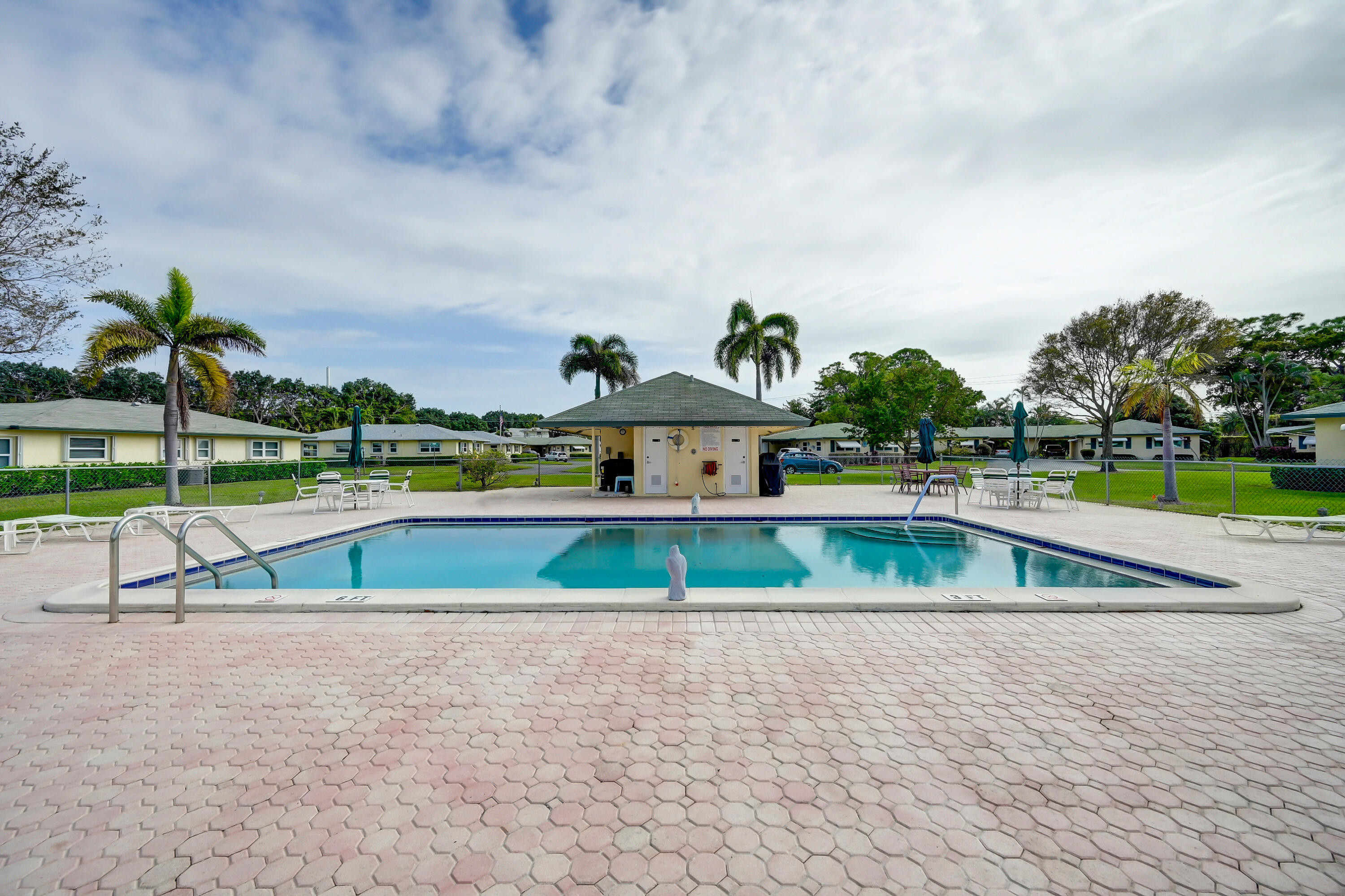 227 Cardinal Lane Delray Beach, FL 33445 - Photo 28 of 38 a view of a swimming pool with a lake in the back