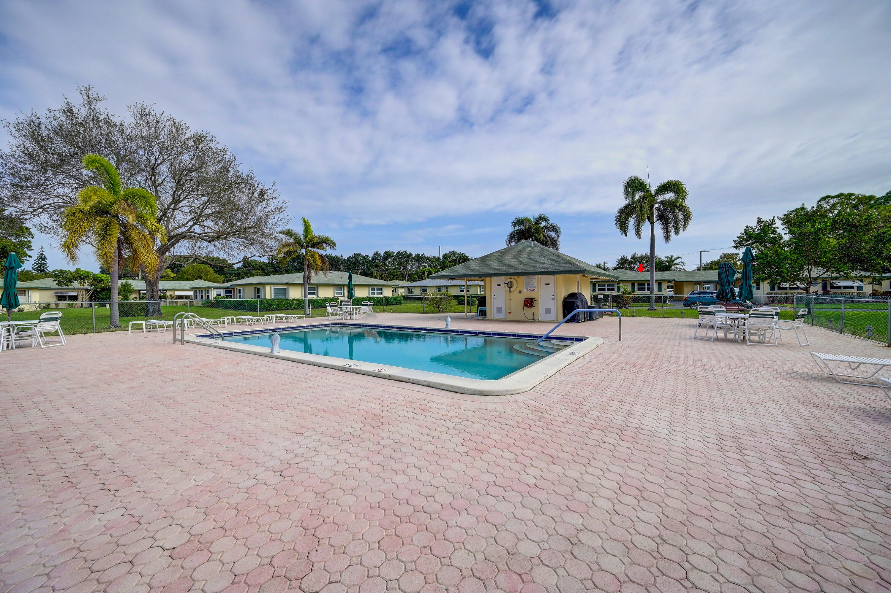 227 Cardinal Lane Delray Beach, FL 33445 - Photo 29 of 38 a view of a swimming pool and trees in the background