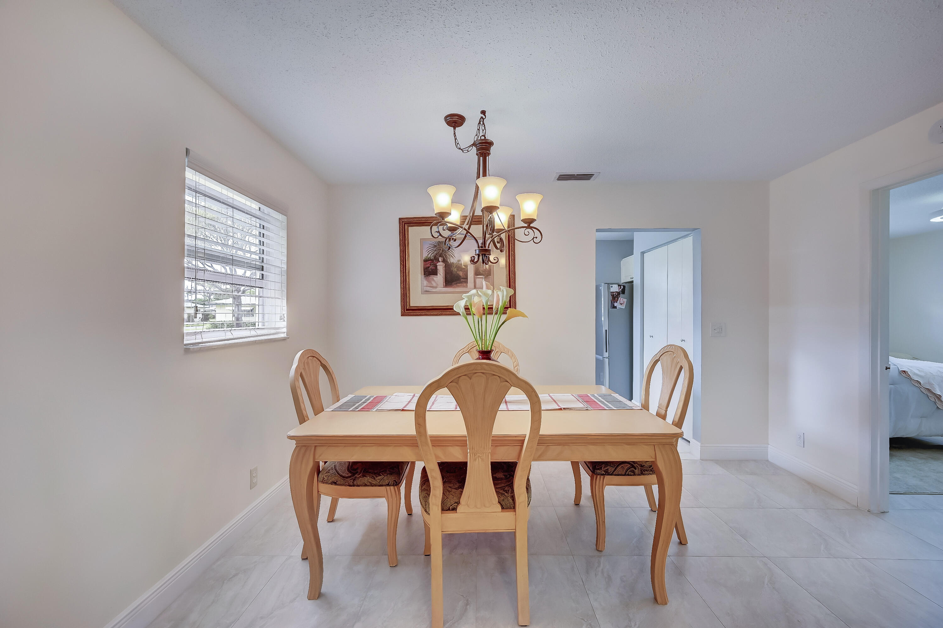 227 Cardinal Lane Delray Beach, FL 33445 - Photo 8 of 38 a dining room with furniture a chandelier and window