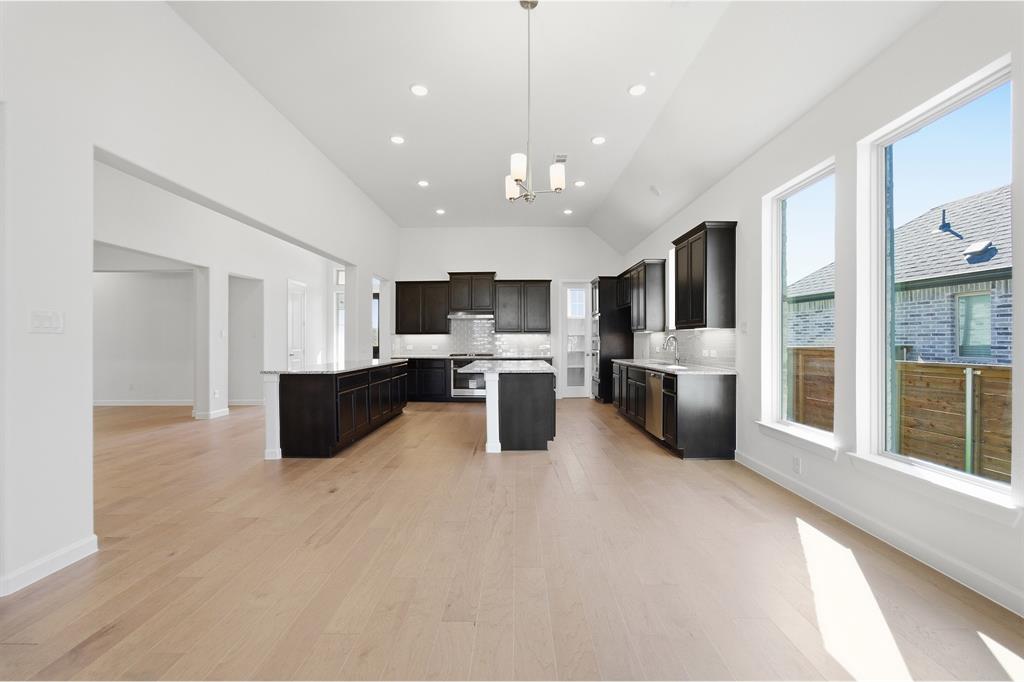 2020 Casting Ridge Mesquite, TX 75181 - Photo 11 of 34 Spacious kitchen featuring dark cabinetry, two islands with countertop space, stainless steel appliances, and wood-finish flooring