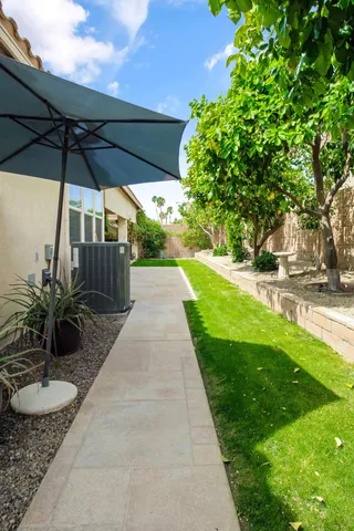 a view of a backyard with table and chairs under an umbrella