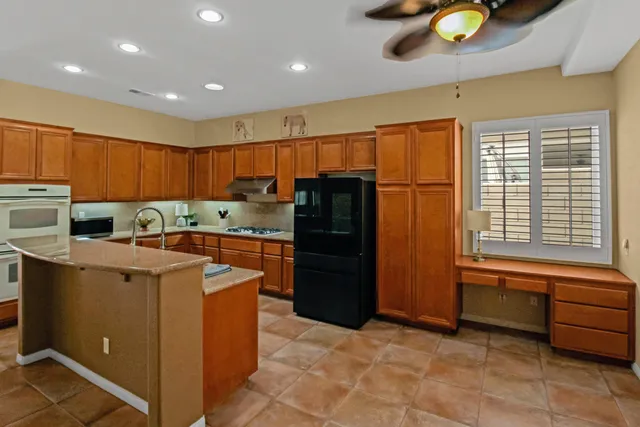 a kitchen with a refrigerator and a stove top oven