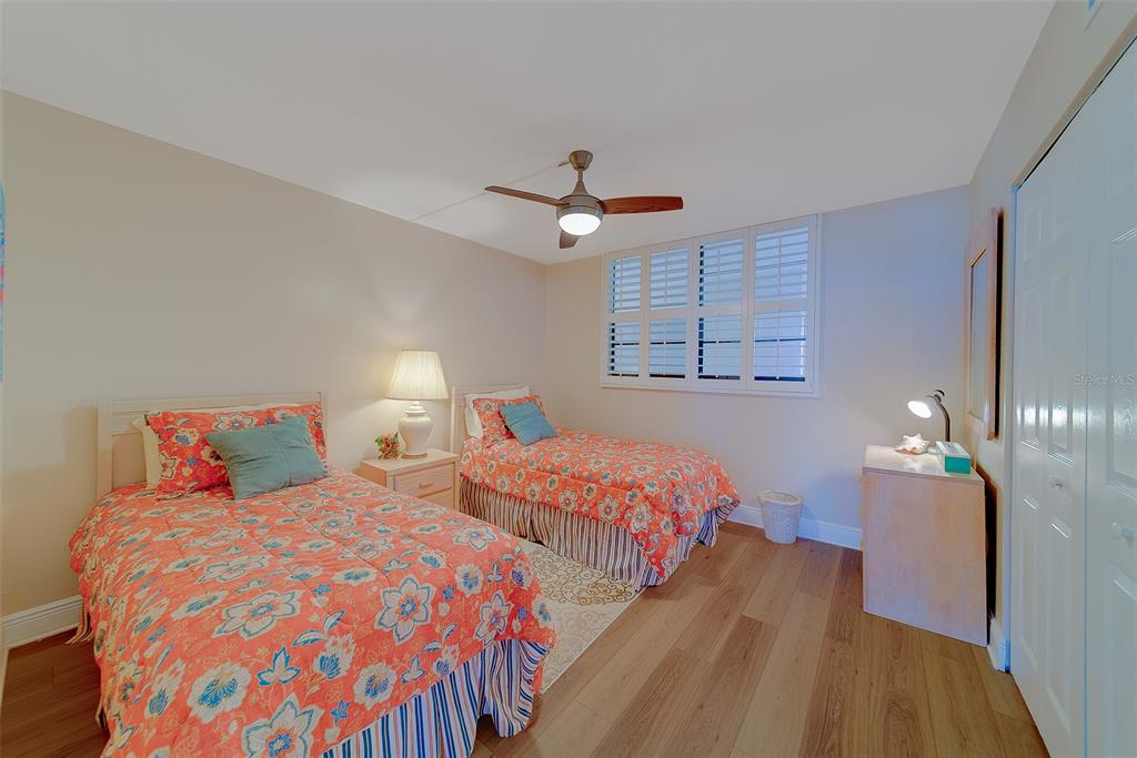 18304 Gulf Boulevard, Unit 102 Redington Shores, FL 33708 - Photo 26 of 55 a bedroom with two beds and a chandelier