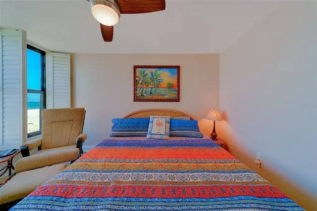 a bedroom with a bed and a large window