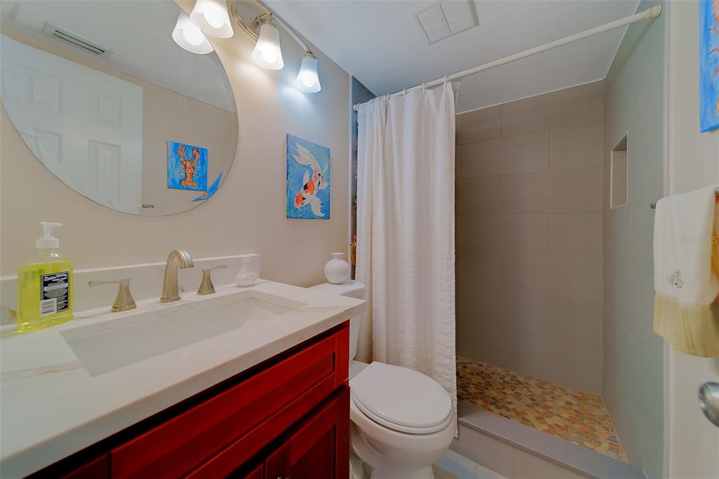 18304 Gulf Boulevard, Unit 102 Redington Shores, FL 33708 - Photo 36 of 55 a bathroom with a sink vanity mirror and toilet