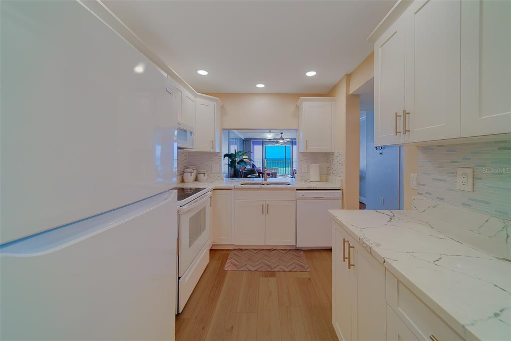 18304 Gulf Boulevard, Unit 102 Redington Shores, FL 33708 - Photo 8 of 55 a kitchen with a sink stainless steel appliances and cabinets